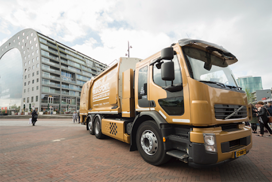 Een goudegekleurde vuilniswagen bij de markthal in Rotterdam